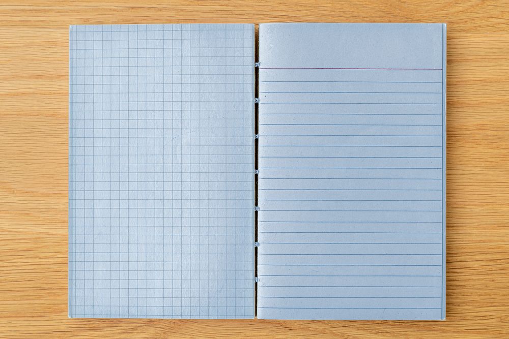 Blue grid and lined notebook mockup on a wooden table