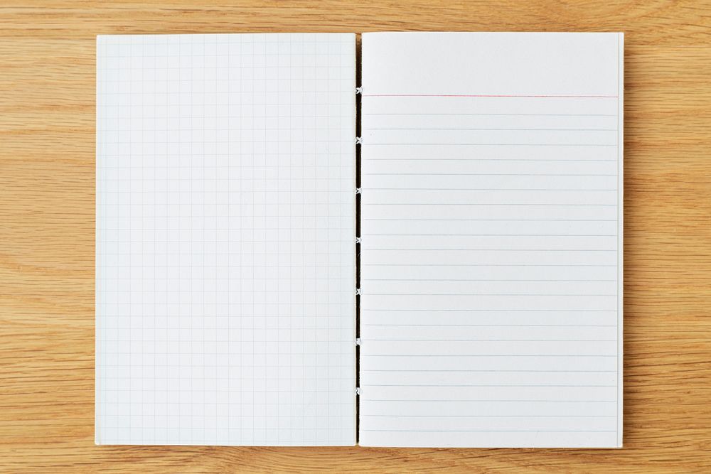 White grid and lined notebook mockup on a wooden table