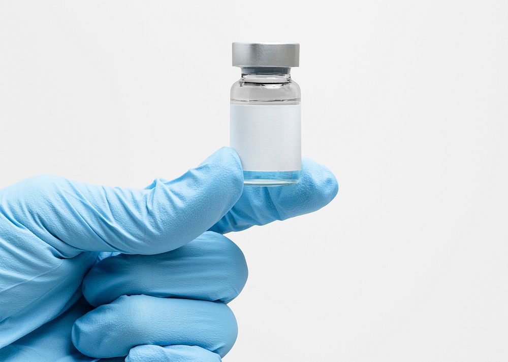 Medicine vial with label mockup psd in gloved hand
