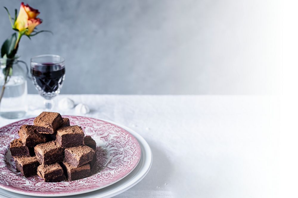 Chocolate ganache truffle squares dusted with cacao powder on a dining table 