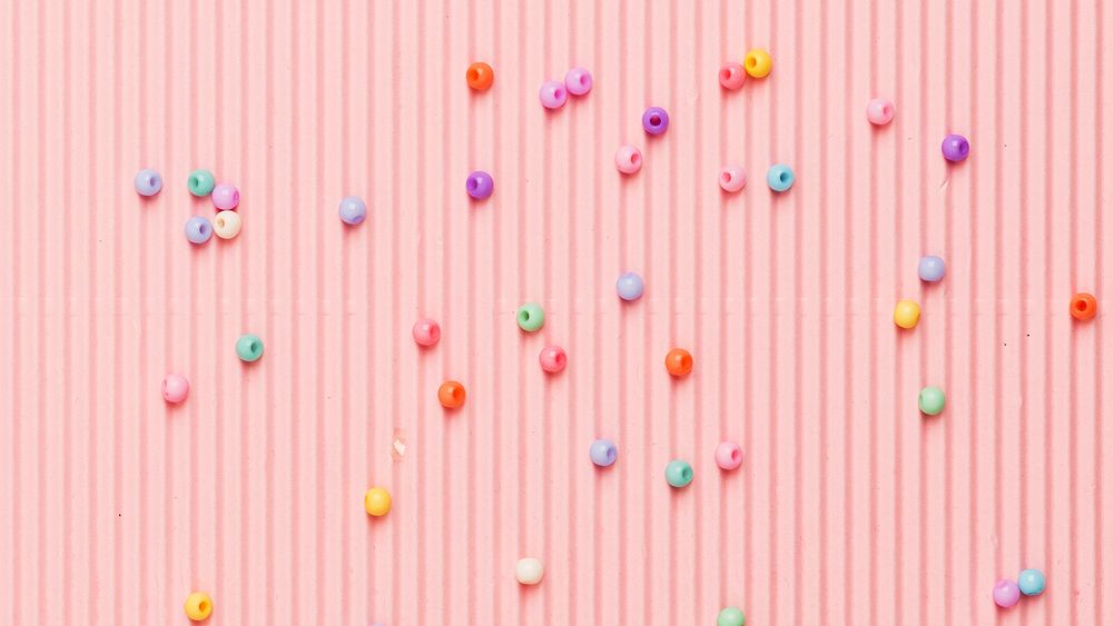 Beads on pink wavy paper banner background