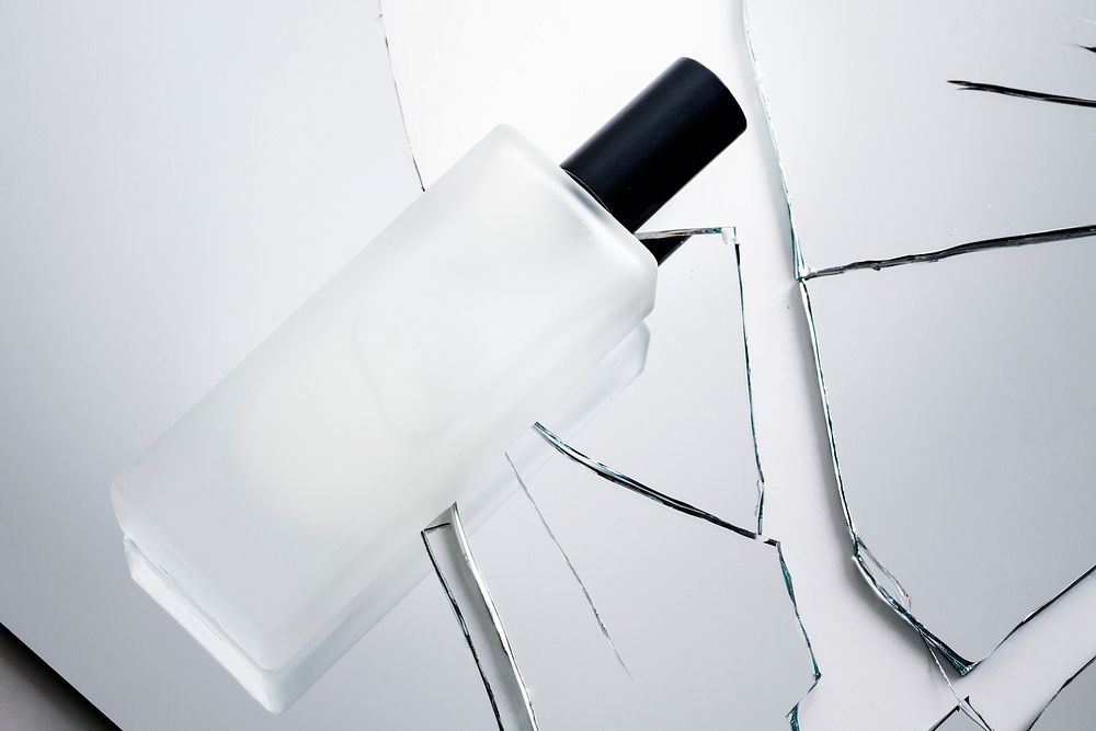Cosmetic bottle on pieces of broken shattered glass