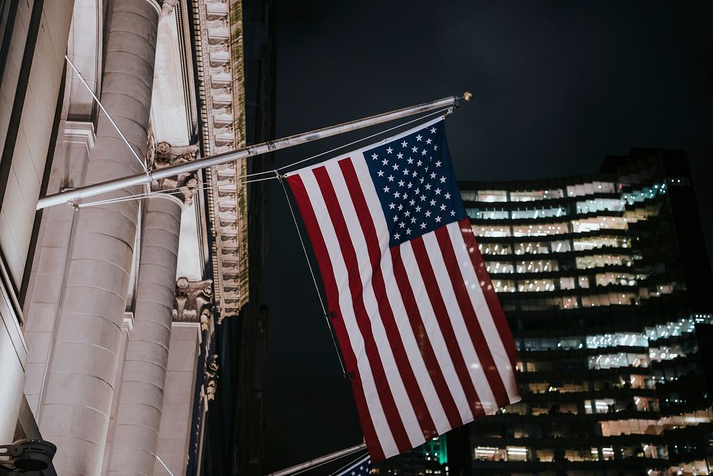 American flag in front of a building at night