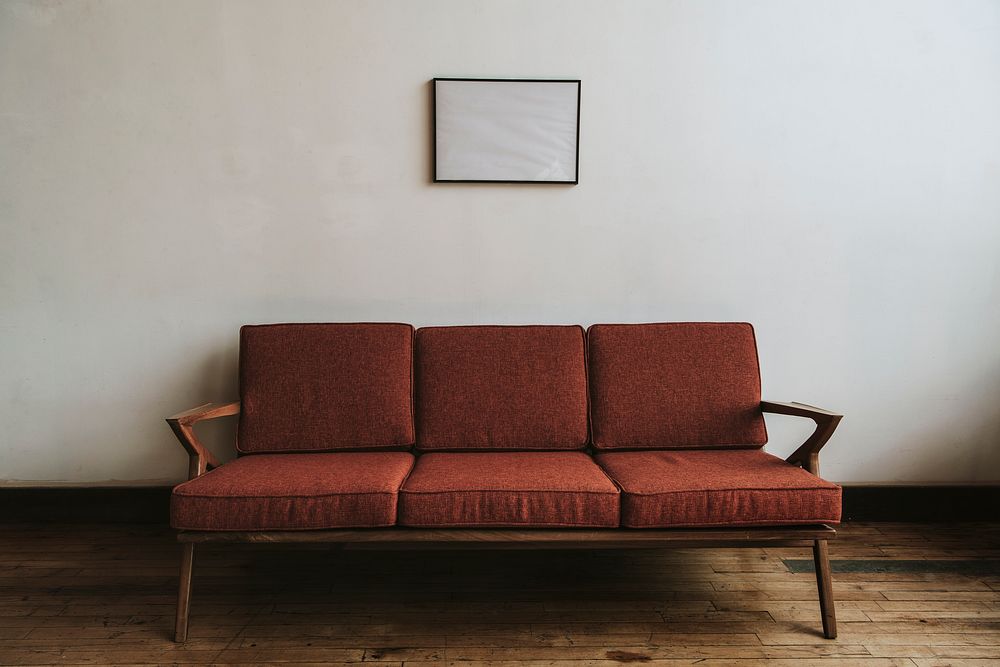 Red couch by a white wall