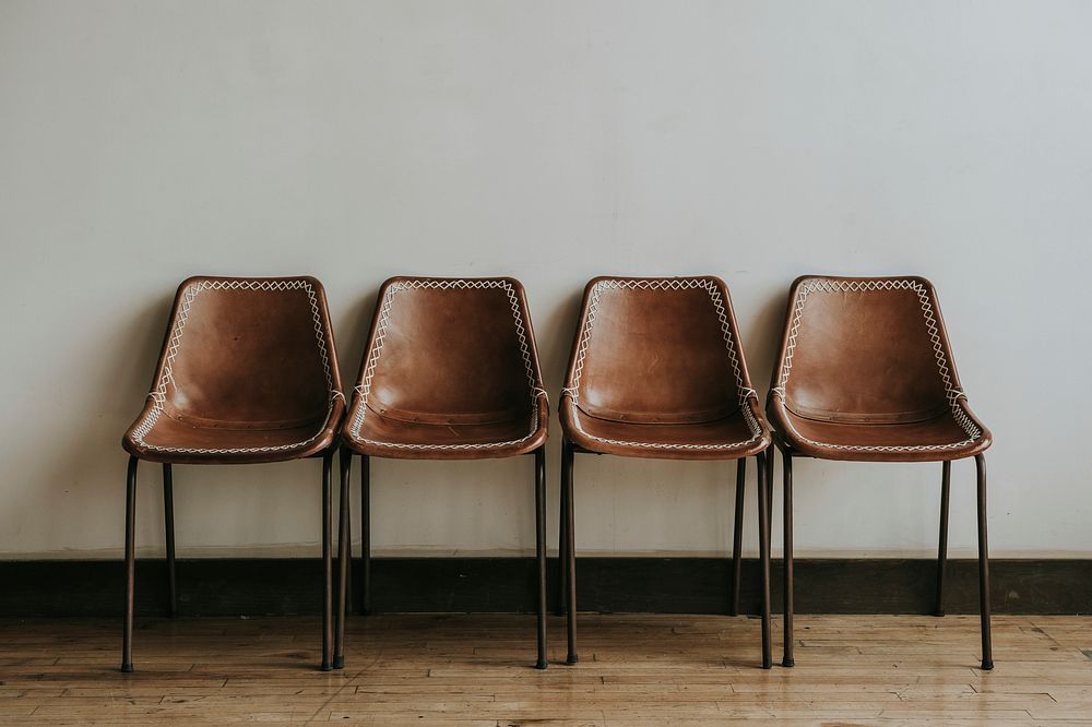 Four empty brown chairs in a room