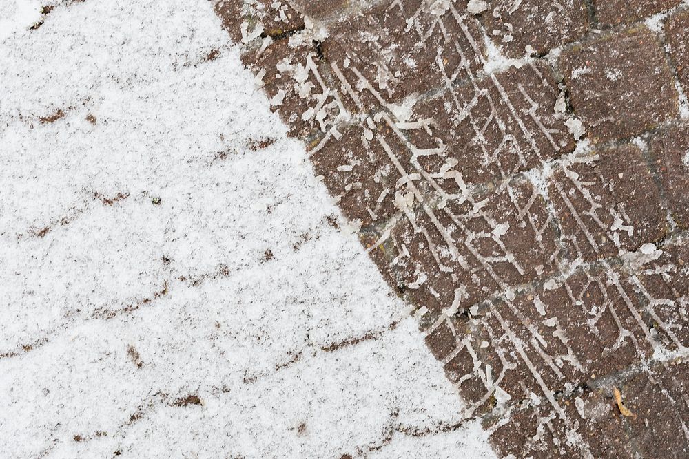 Skid marks on a a snowy cobblestone road background