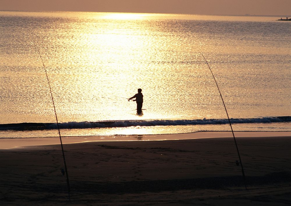 A Rock Fishing Scene At Sunset