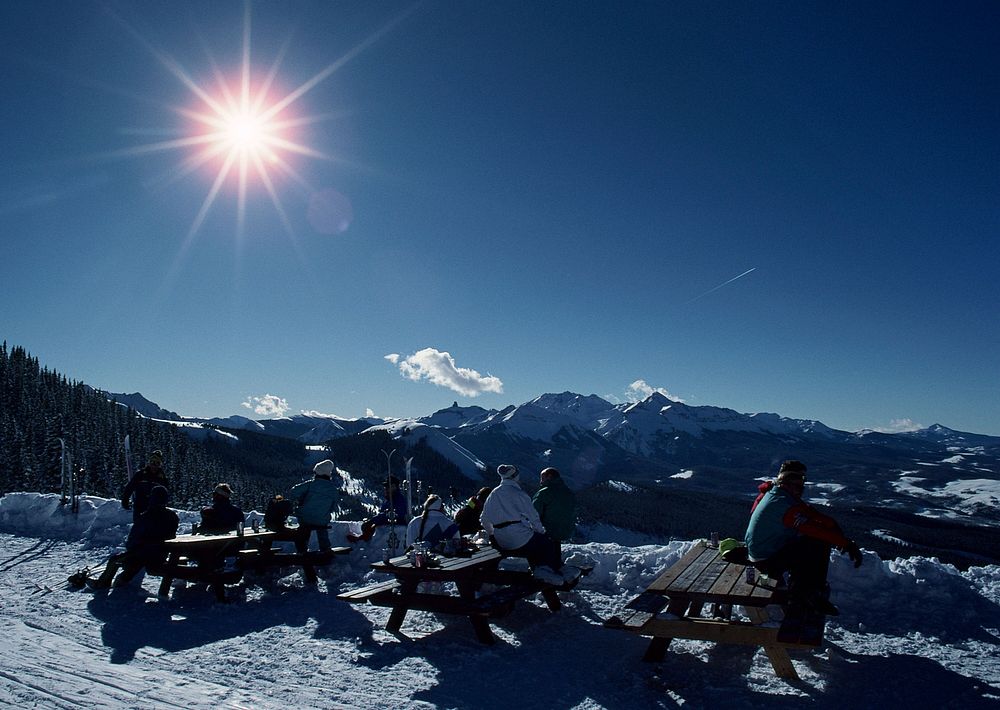 Skiers Resting On Deckchair In Snowy Mountains