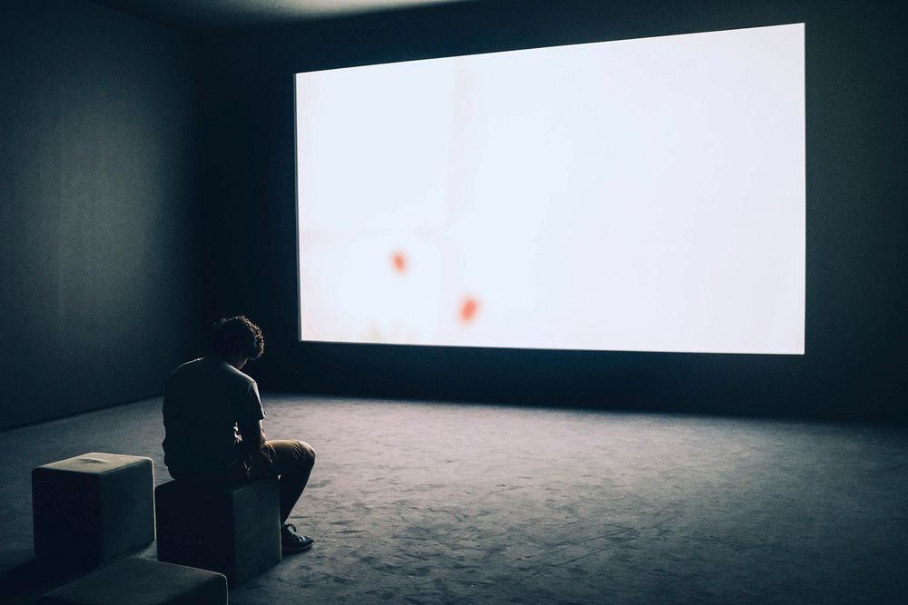 Silhouette Of Man's Head In Front Of Screen Light At Night