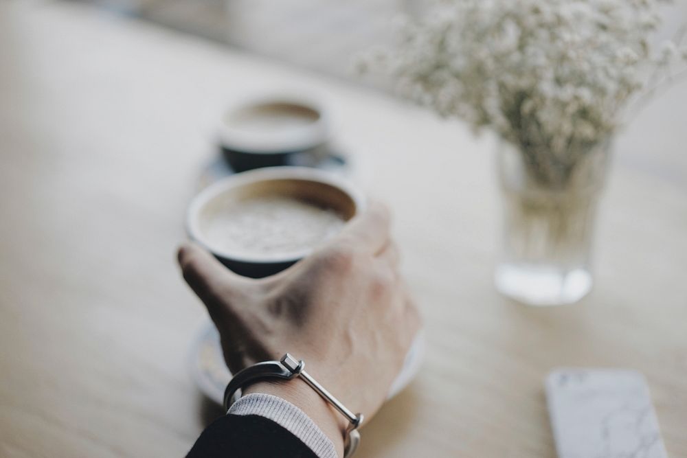 Free hand holding coffee cup at cafe photo, public domain beverage CC0 image.