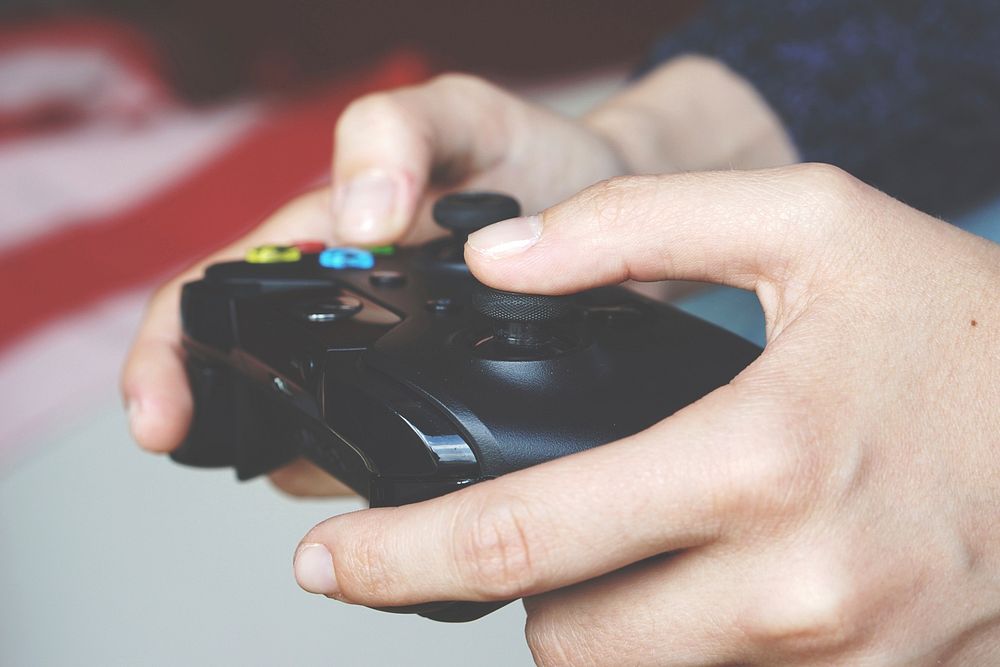 Free hand holding gaming console photo, public domain CC0 image.