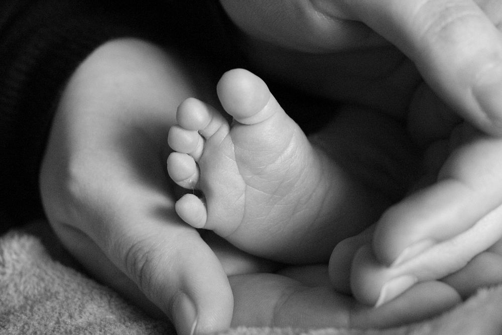 Mother holding baby feet. Free public domain CC0 photo.