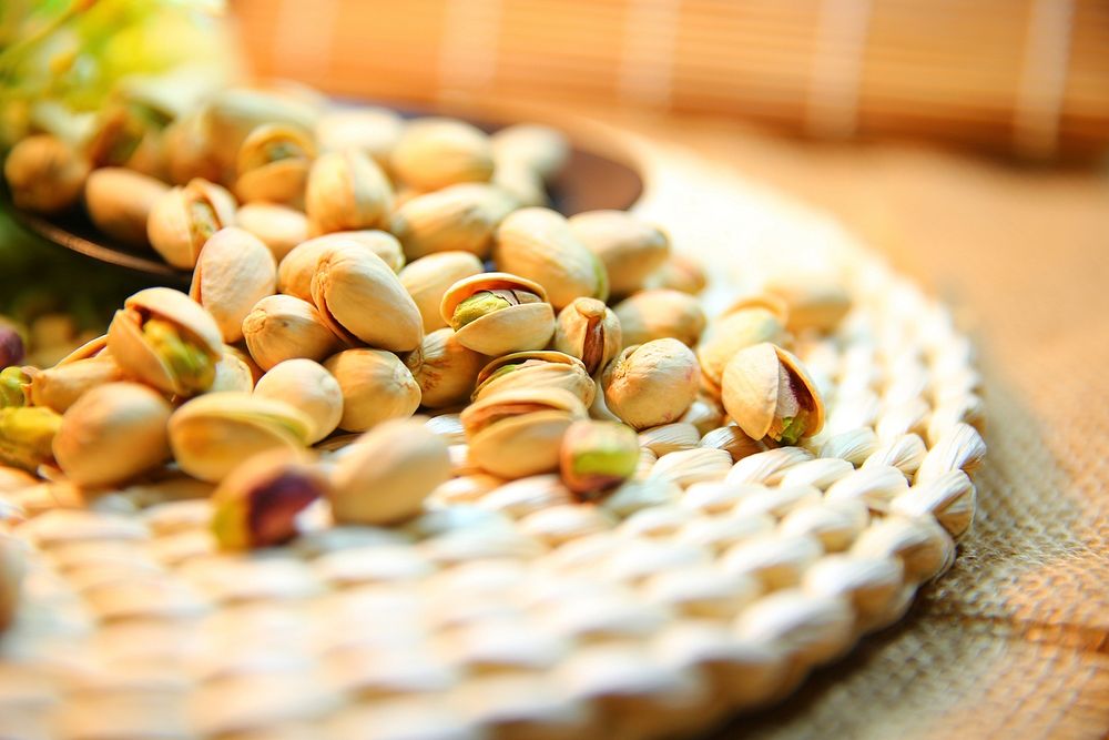 Free pile of pistachio nuts on table photo, public domain food CC0 image.