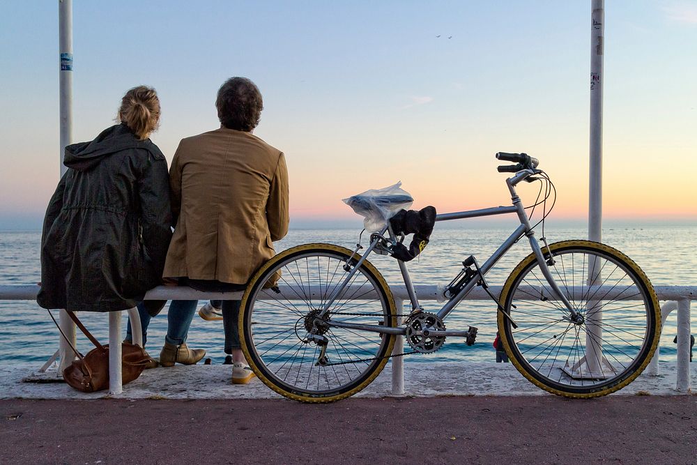 Free couple sitting next to a bike image, public domain scenery CC0 photo.