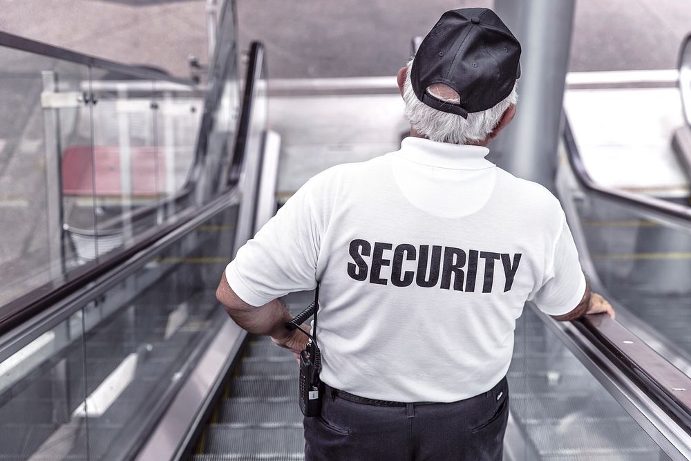 Free back of a security on escalator image, public domain CC0 photo.