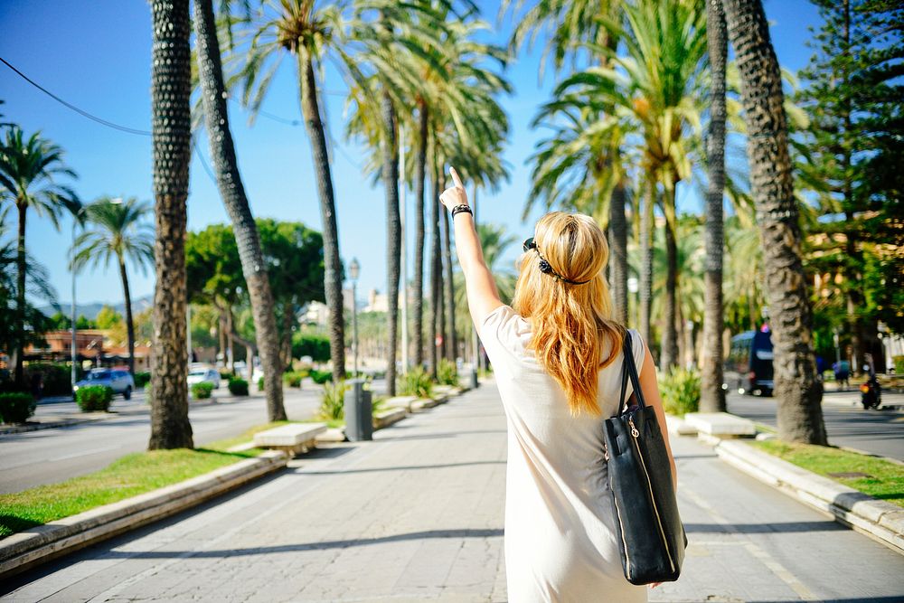 Free woman walking on road with palm tree image, public domain CC0 photo.