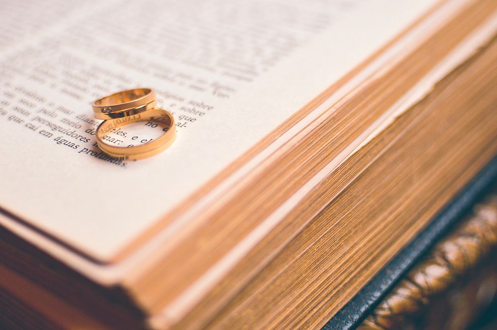 Free wedding rings on book photo, public domain CC0 image.