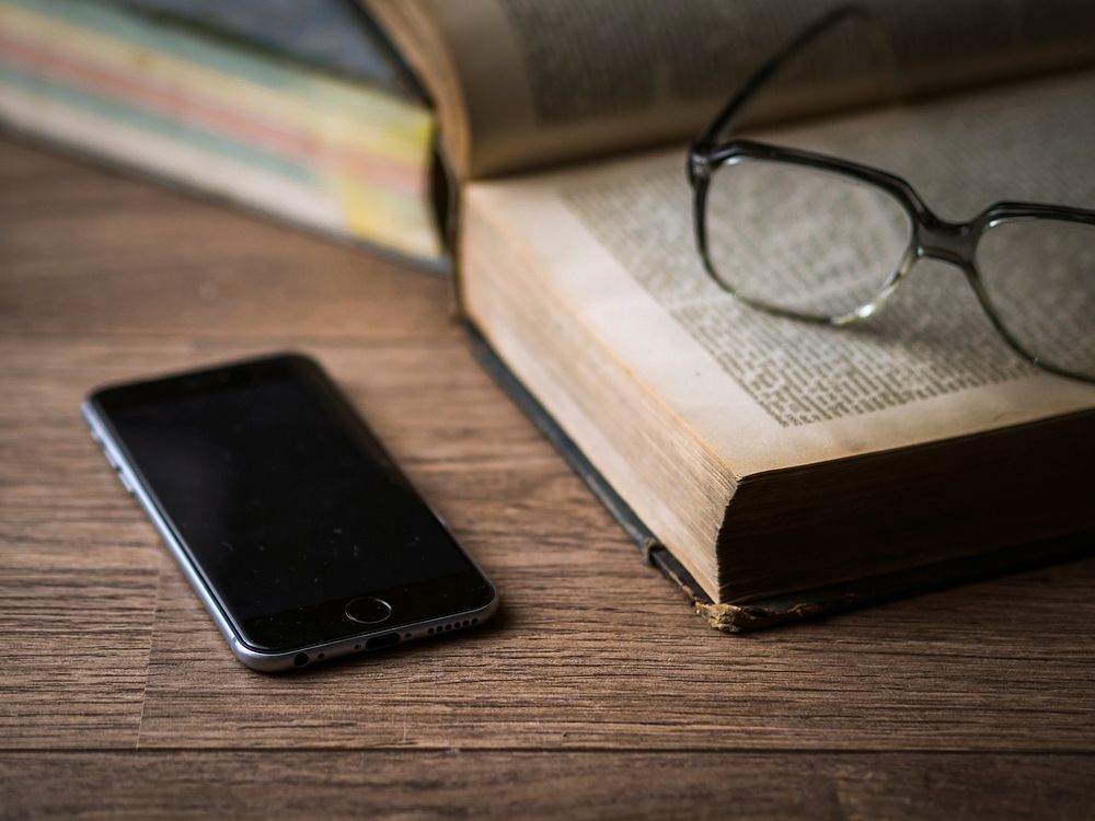 Free blank smartphone screen next to a book image, public domain CC0 photo.