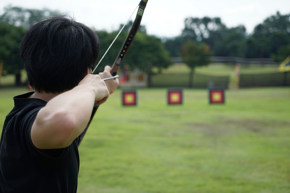 Free man aiming bow and arrow towards target image, public domain sport CC0 photo.