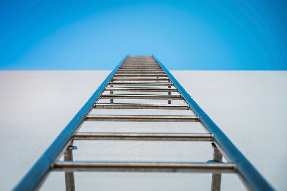 Free blue ladder on white wall photo, public domain steps CC0 image.