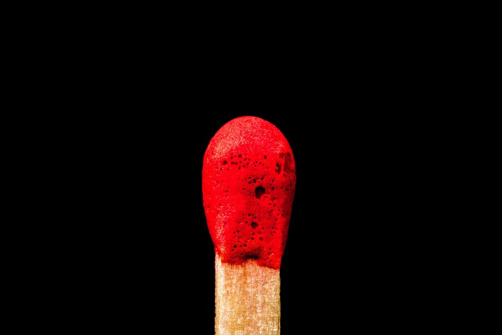 Red match head in black background photo, free public domain CC0 image.