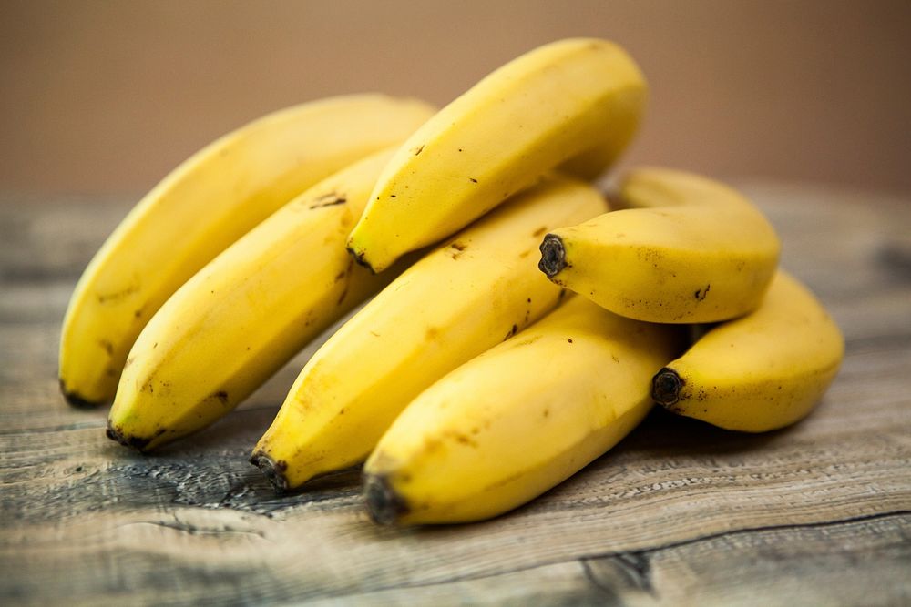 Free bunch of bananas on wooden table image, public domain CC0 photo.
