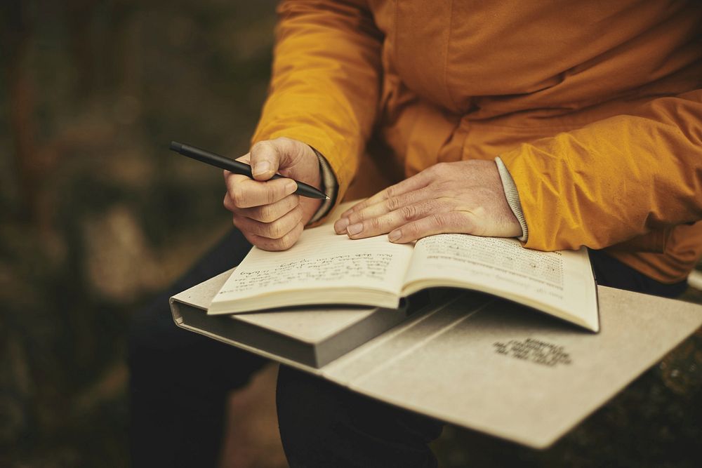 Free close up of a hand writing notes in a journal photo, public domain CC0 image.