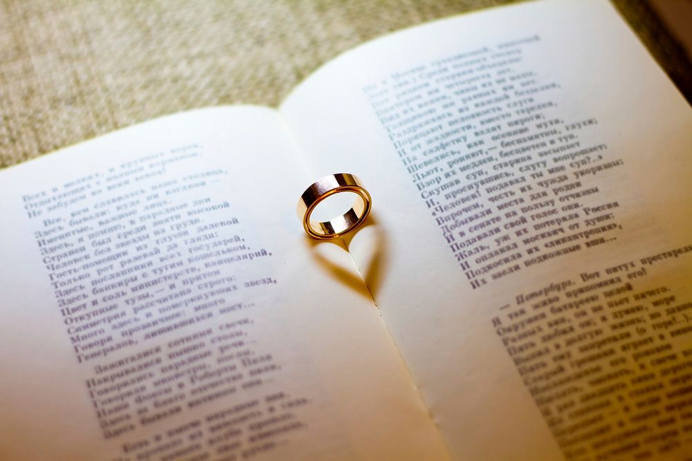 Free heart shadow from wedding ring on book photo, public domain CC0 image.