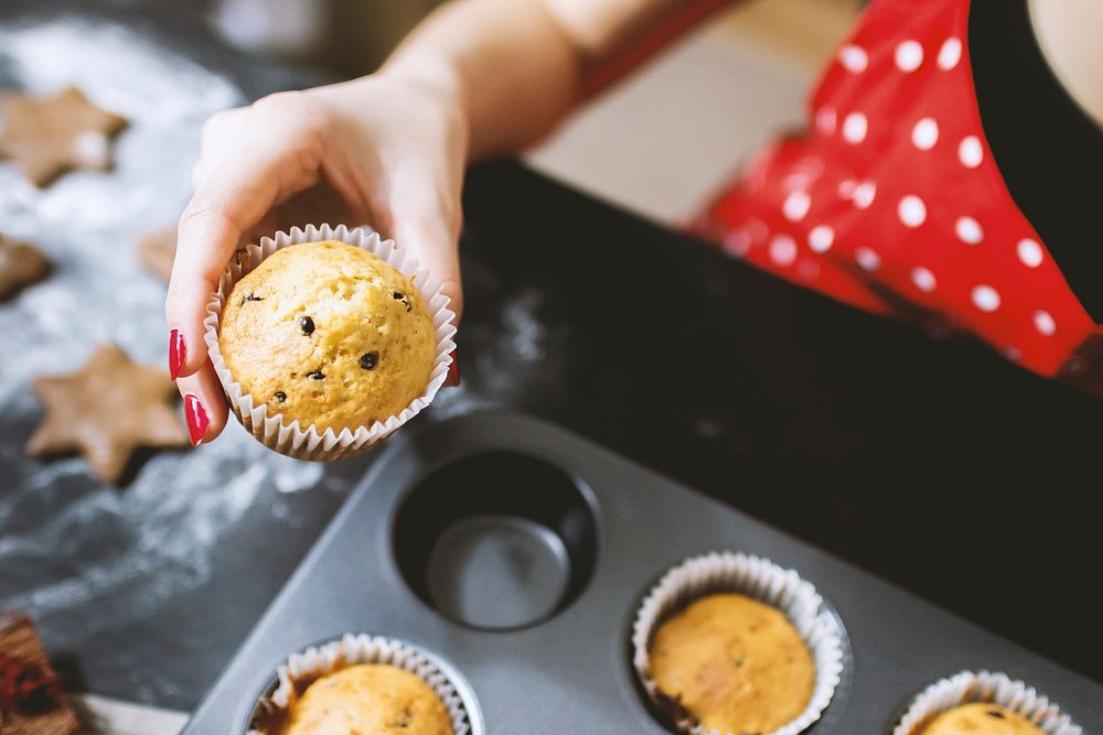 Freshly baked muffin in woman's hand. Free public domain CC0 photo.