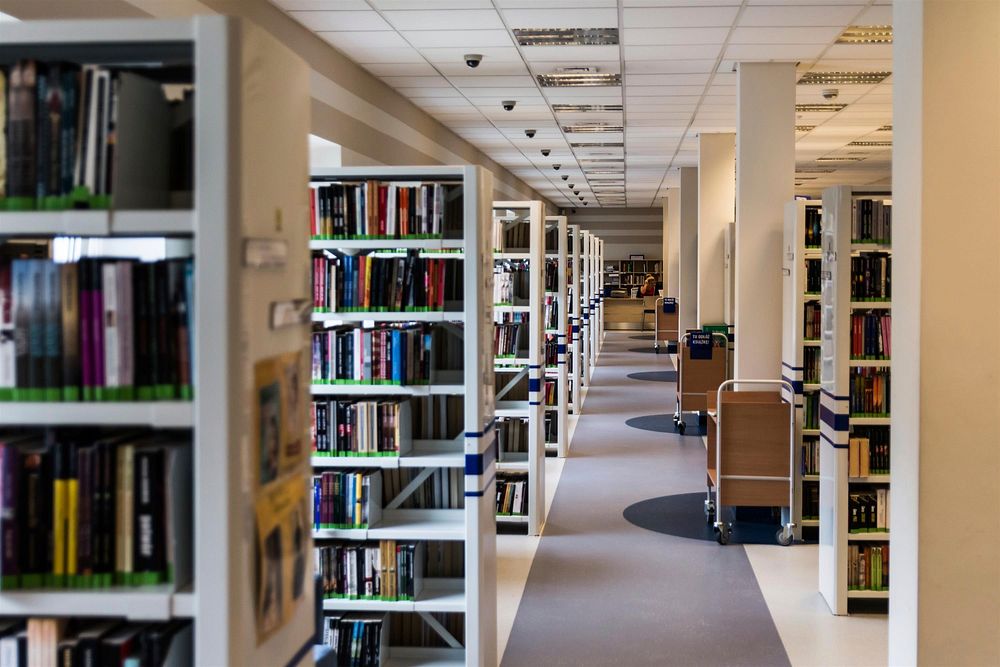 Free library shelves with many books photo, public domain CC0 image.