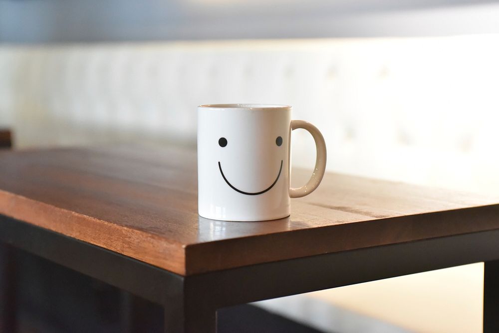 Free smiley face coffee cup white color on wooden table public domain CC0 photo