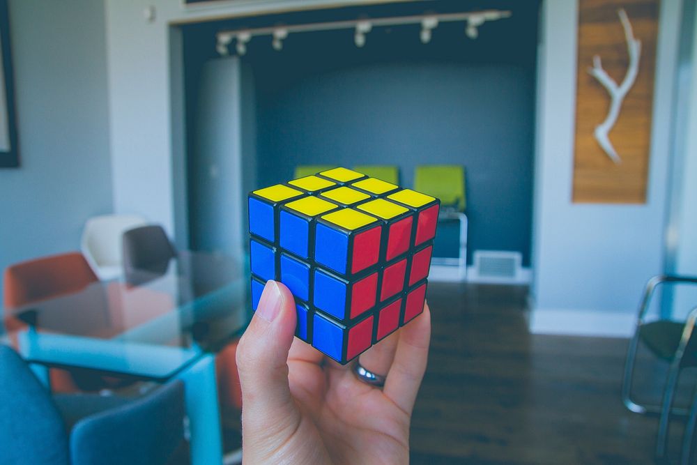 Free holding rubik cube image, public domain game CC0 photo.