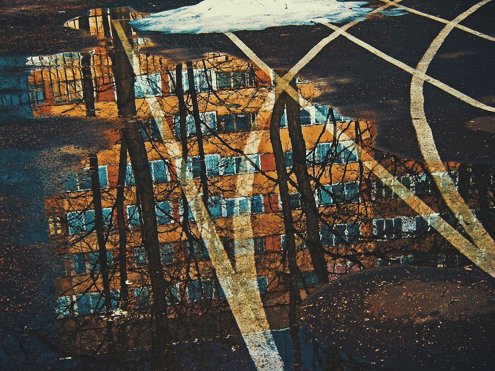 Free reflection of apartment building and tree on water on running lane image, public domain CC0 photo.