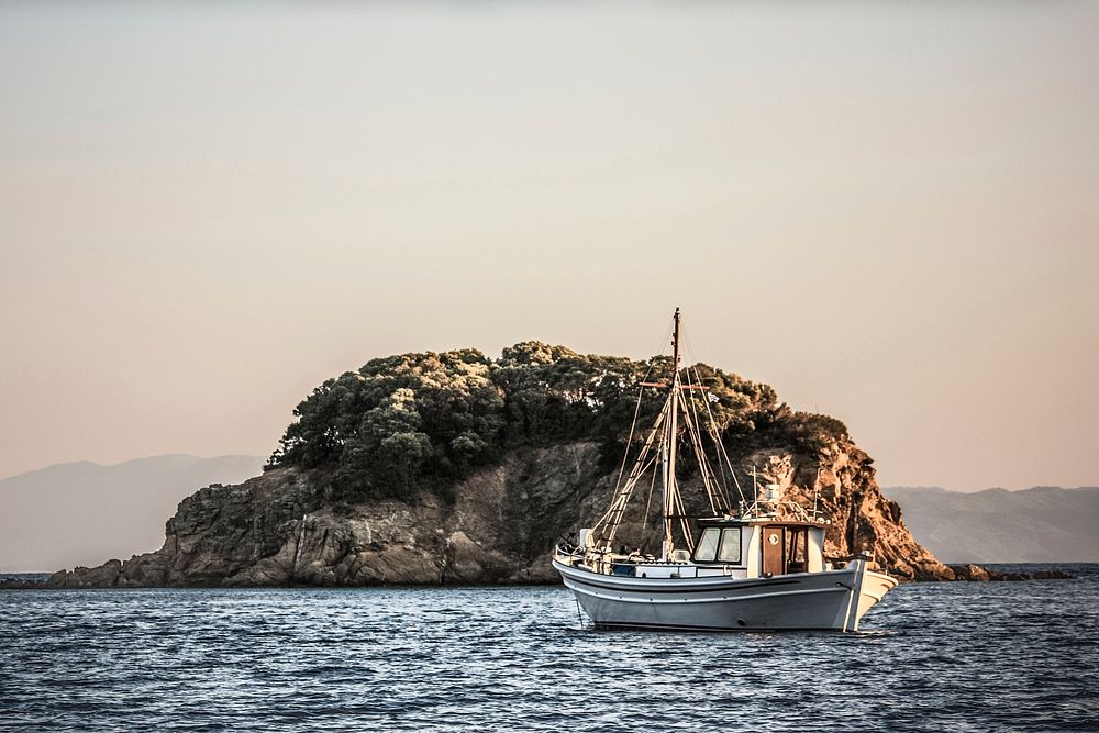 Free fishing boat near small island image, public domain CC0 photo.
