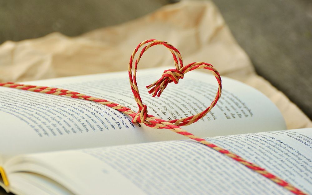 Free rope in the shape of a heart on a book page image, public domain CC0 photo.