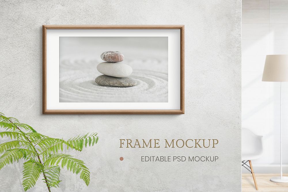 Wooden picture frame mockup psd with zen stones photo on the wall interior concept