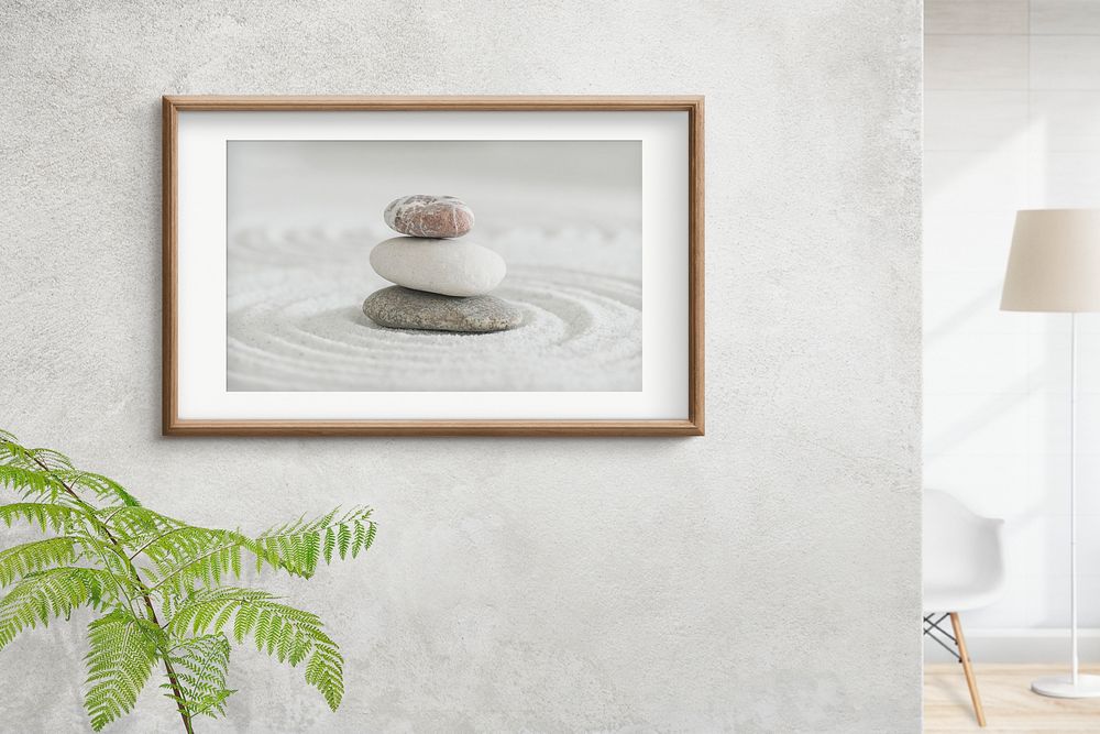 Wooden picture frame with zen stones photo on the wall interior concept