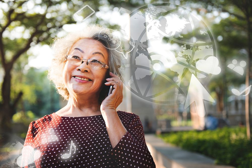Elderly Asian woman talking on a phone in a park
