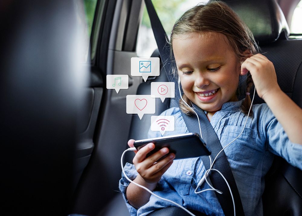 Little girl using a phone in a car