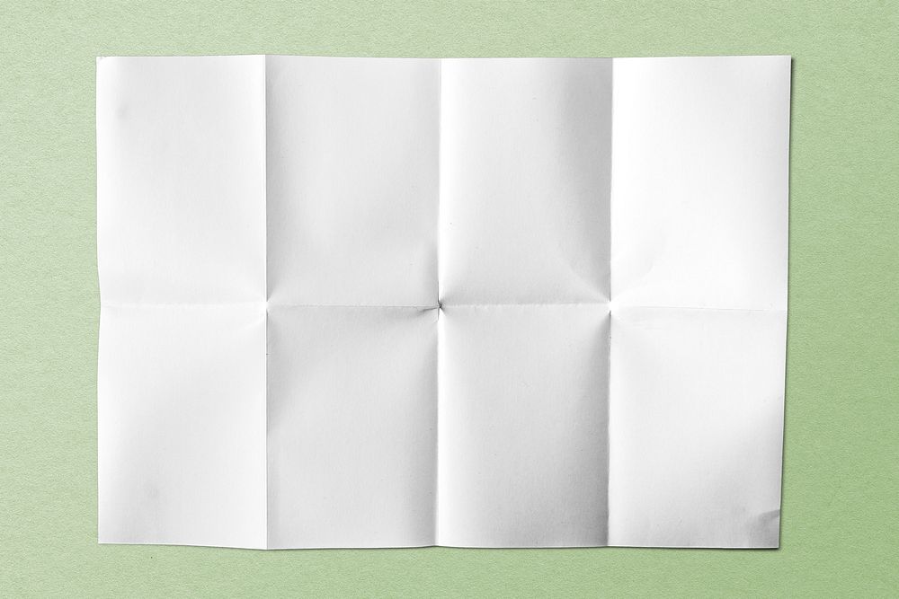 White folded paper on green background