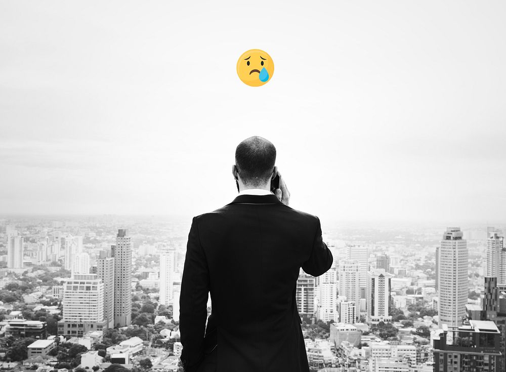 Emoji on a businessman talking on his phone overlooking the city