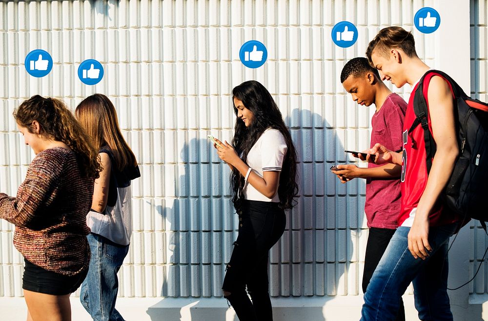 Diverse teenagers using their smartphones while walking home