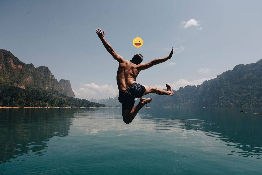 Adventurous man jumping into a lake