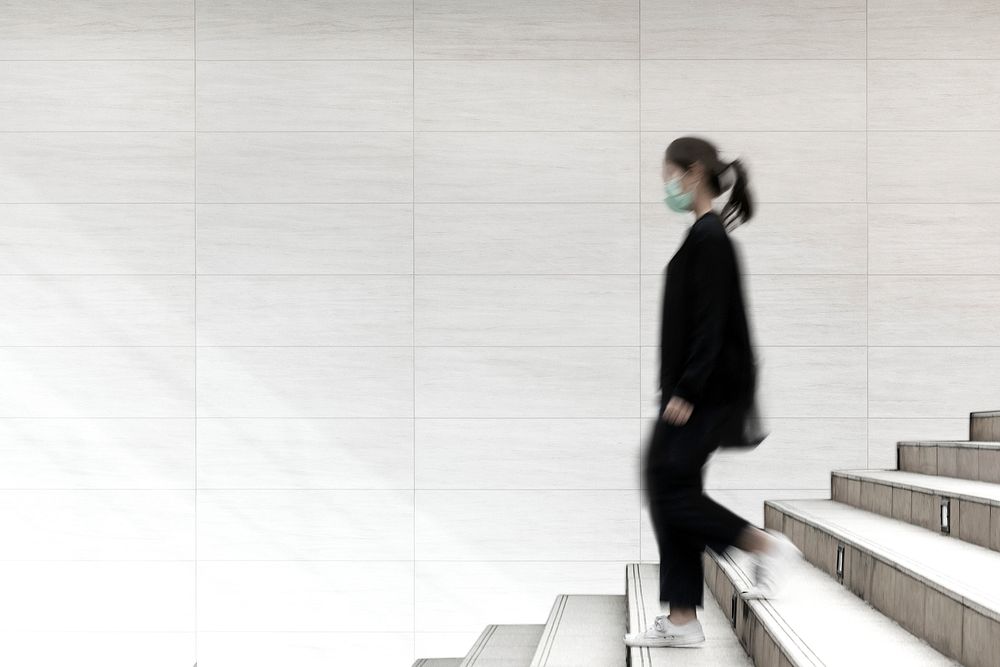 Woman walking down the stair, empty wall with design space