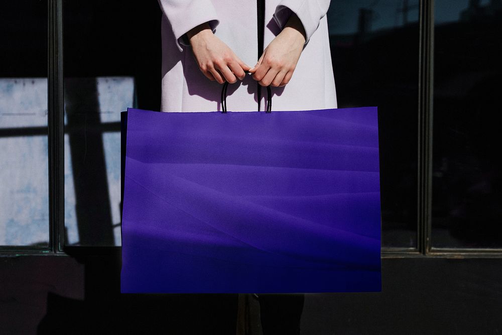 Woman holding blue shopping bag