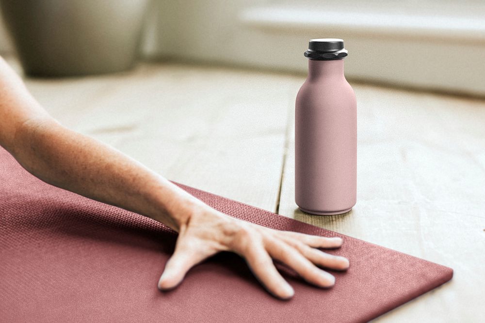Pink bottle near person doing yoga