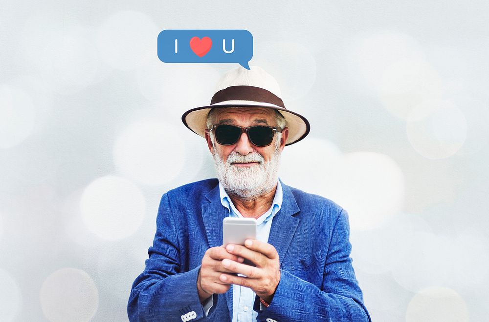 Stylish elderly man texting on his smartphone