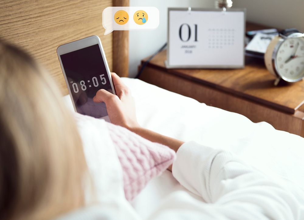 Woman checking her phone in bed