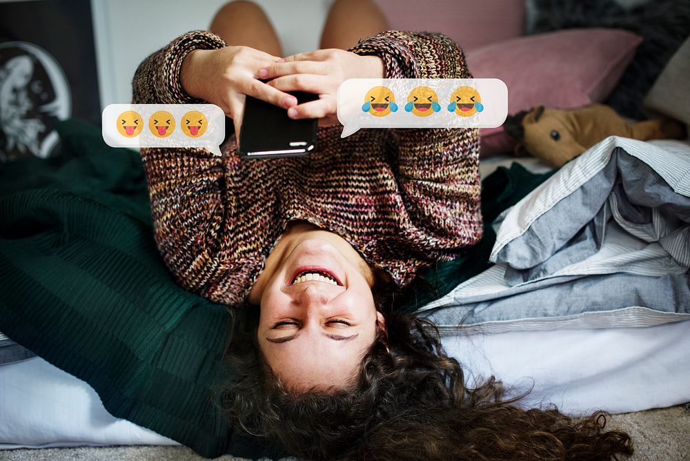 Cheerful woman texting from her bed