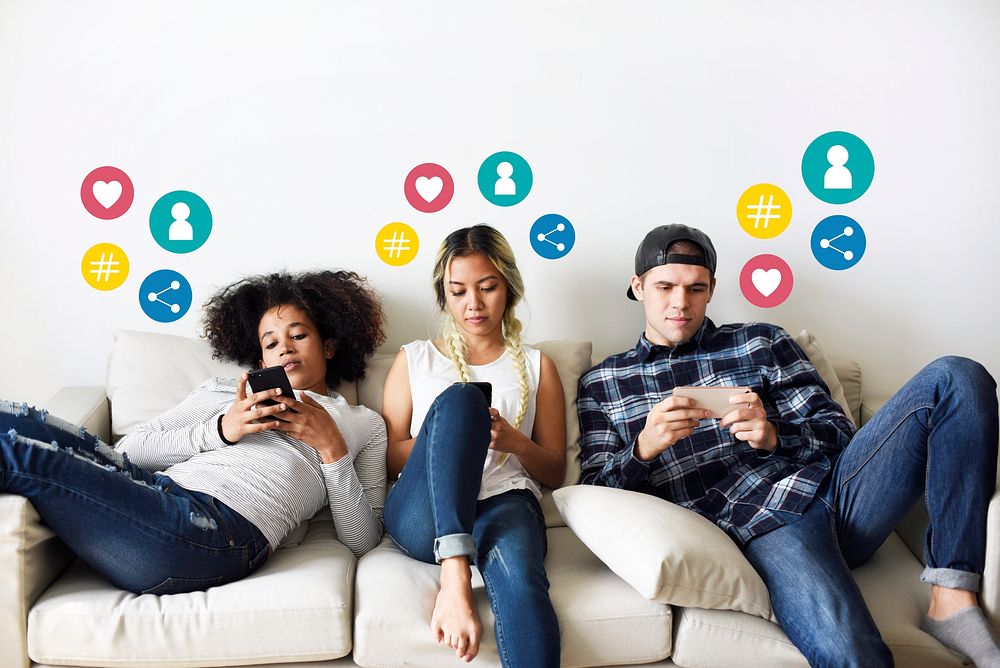 Friends using their mobile phones on the couch
